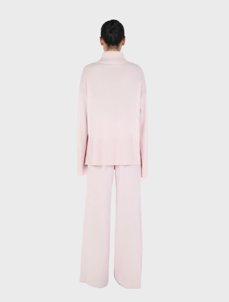 Blush Bay Cashmere Jumper displayed on a hanger, showcasing its soft texture and elegant design.