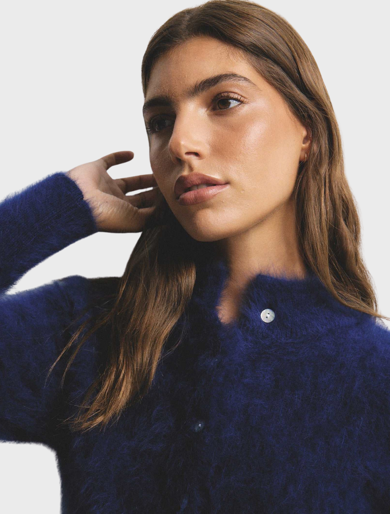 Navy Bella Cashmere Cardigan displayed, illustrating its smooth texture and timeless design suitable for various outfits.