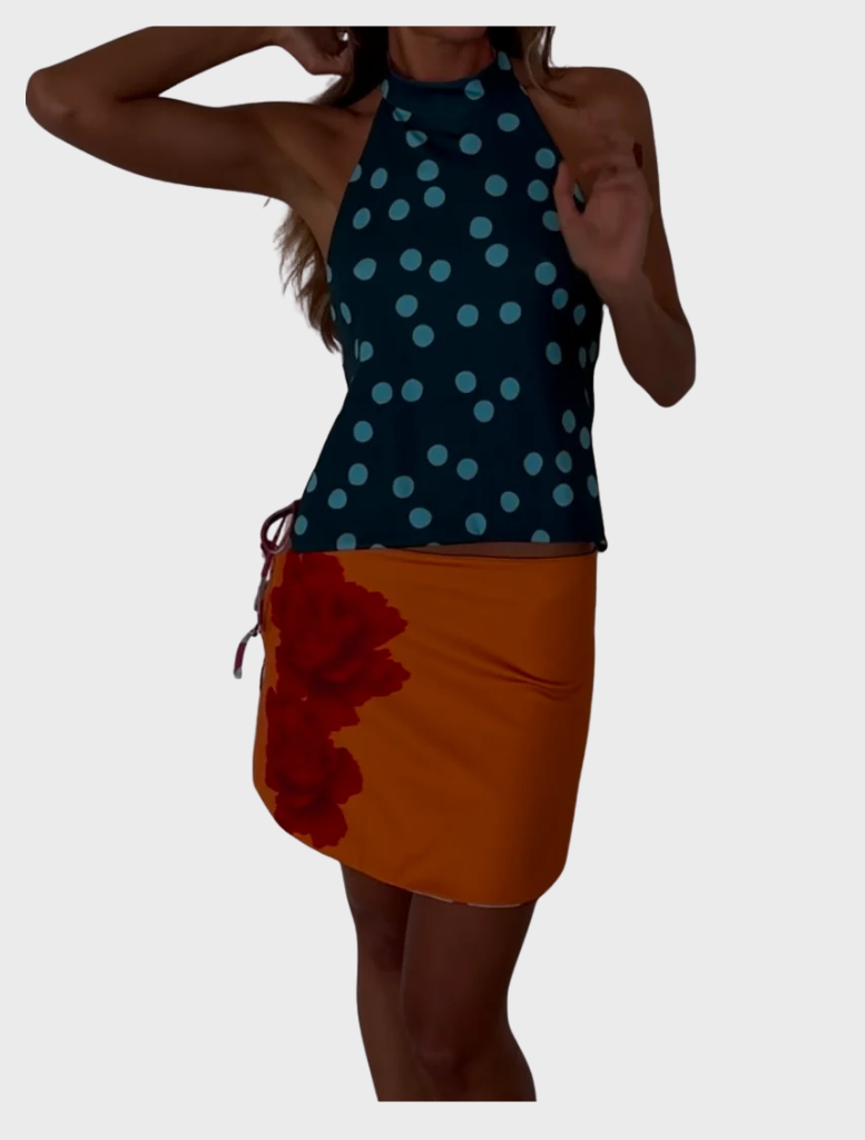 A woman dressed in a blue doted tank top and an orange skirt smiles, embodying a cheerful and fashionable look.