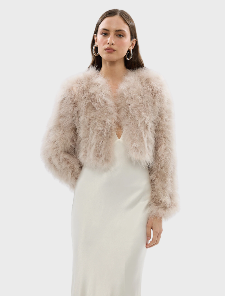 Blush Manhattan crop jacket displayed on a hanger, featuring a stylish design and modern cut for a chic look.