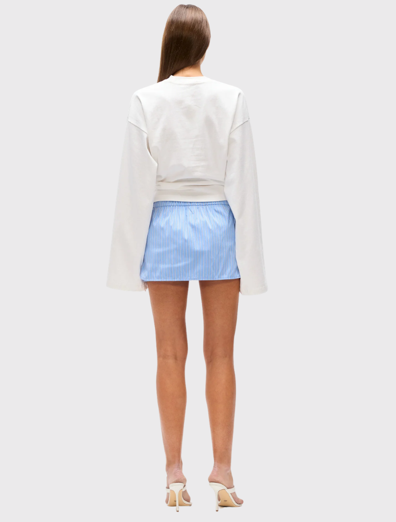 The Margaux Skort in blue stripes has a mini length, built-in shorts, and an elastic drawstring waistband for comfort.