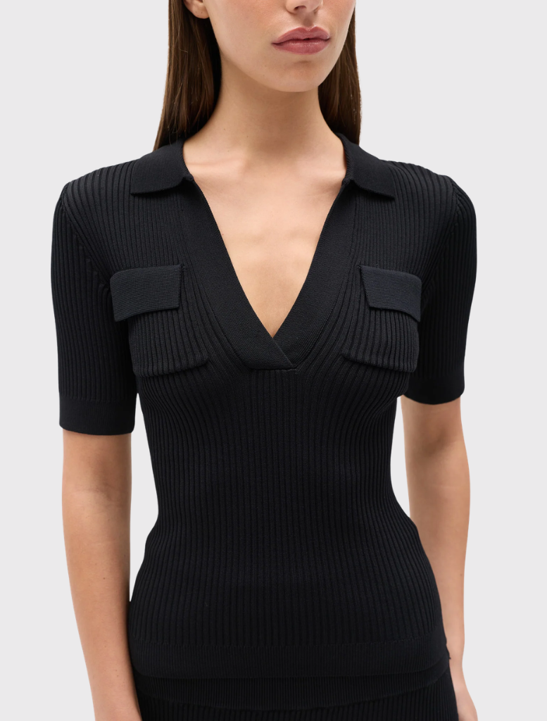 Black polo shirt in ribbed knit, featuring a deep V neckline, short sleeves, and flap pockets on the chest.
