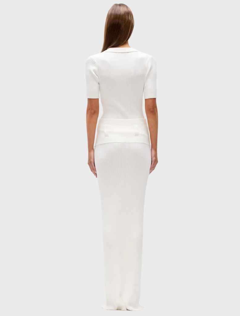 Ivory polo in ribbed knit, designed with a deep V neckline, short sleeves, and flap pockets on the chest for added detail.