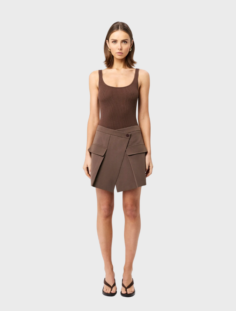 Mocha Vault Mini Skirt draped elegantly, emphasizing its modern cut and rich color on a plain surface.