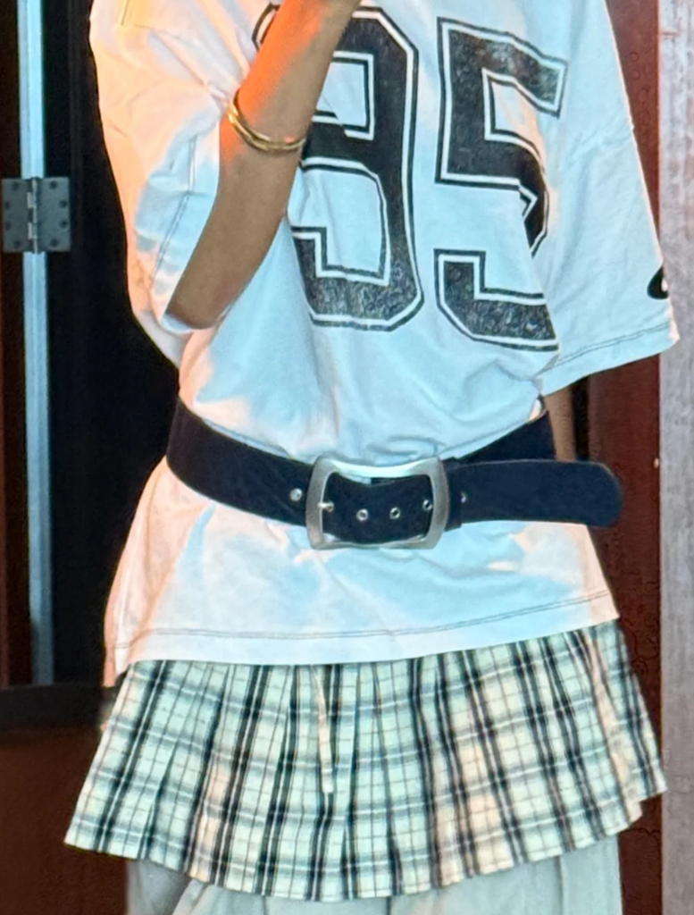 A woman in a navy blue coat and hat smiles as she takes a selfie, capturing a moment of joy.