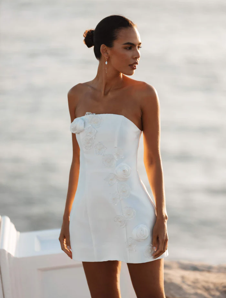 Elegant white maxi dress featuring a strapless design and vibrant oleander floral print, ideal for warm weather occasions.