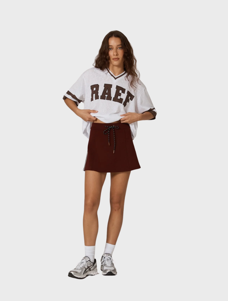 Stylish burgundy Palmer mini skirt shown on a white surface, illustrating its modern design and rich color.