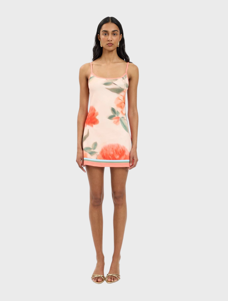 Peach-colored mini dress with a floral print, designed to fit closely and enhance the wearer's figure.