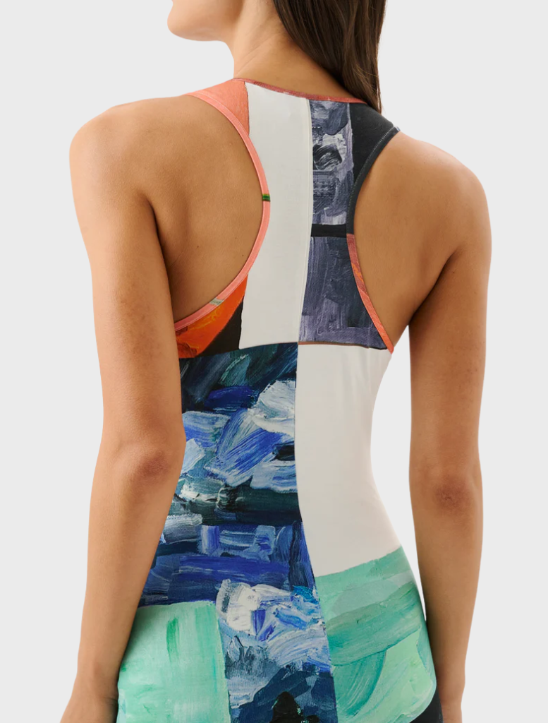 A woman models a bright dress adorned with colorful flowers, highlighting her cheerful style.