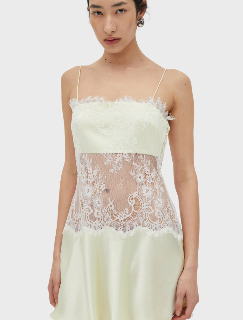 Lemonade-colored mini dress with lace overlay, fitted bodice, rouleau straps, and a flared skirt, finished with a side closure.