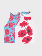 A woman takes a cheerful selfie with a white wall as her backdrop.