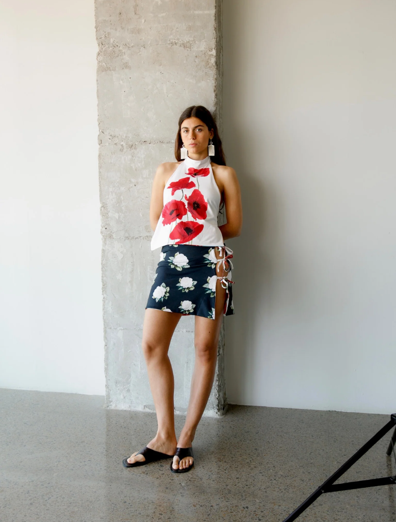 A woman dressed in a blue and pink floral top, looking off to the side with a pleasant expression.