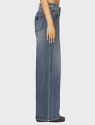 A close-up of the 95 Super Baggy jeans, emphasizing the fabric texture and relaxed silhouette in a bright, modern environment.