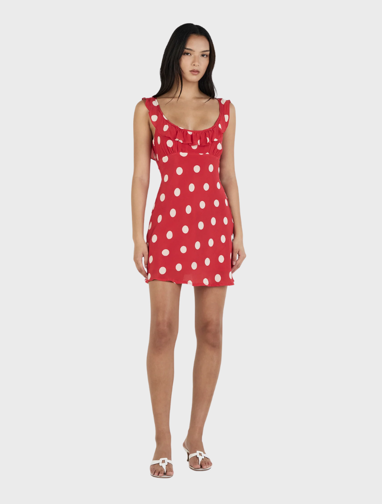 A vibrant red mini dress adorned with white polka dots, featuring a flattering cut and short sleeves for a playful look.