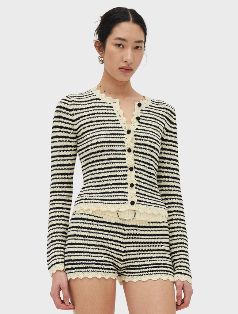 Cream and coffee-colored Resonance knit cardigan displayed on a hanger, showcasing its soft texture and stylish design.