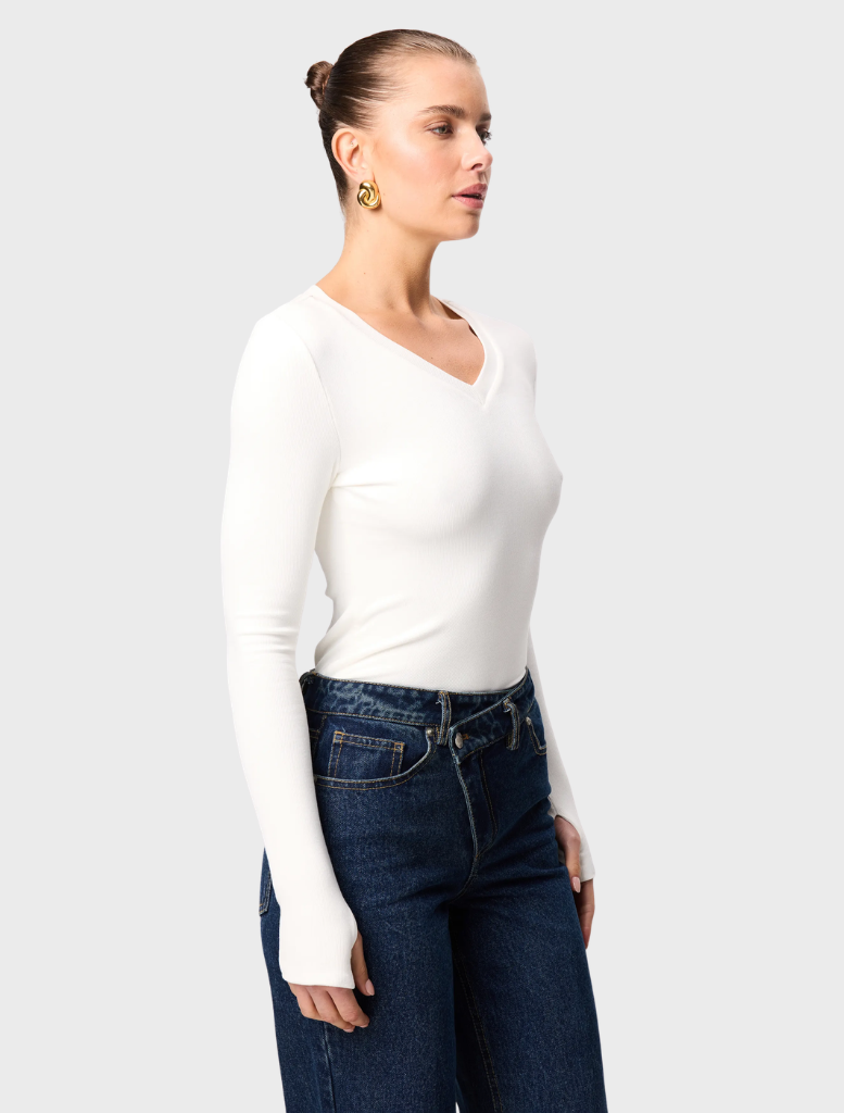 A white Sedona top presented on a hanger, emphasizing its elegant simplicity and suitability for various occasions.