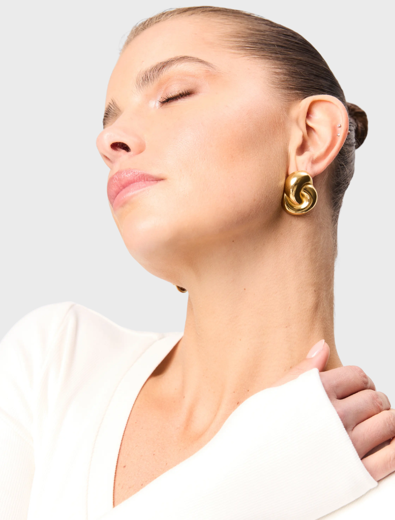 A white Sedona top hanging, showcasing a minimalist style ideal for warm weather and versatile outfits.