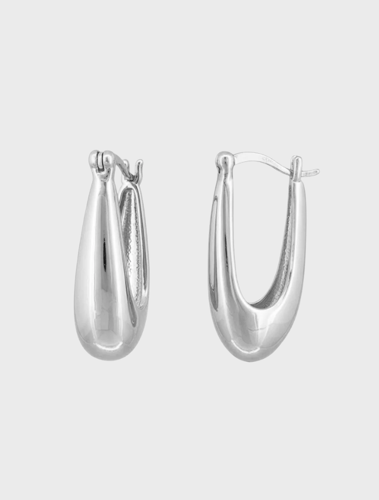 Stylish silver hoop earrings resting on a soft surface, reflecting light beautifully.