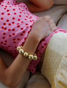 A gold bracelet showcasing a significant round ball design.