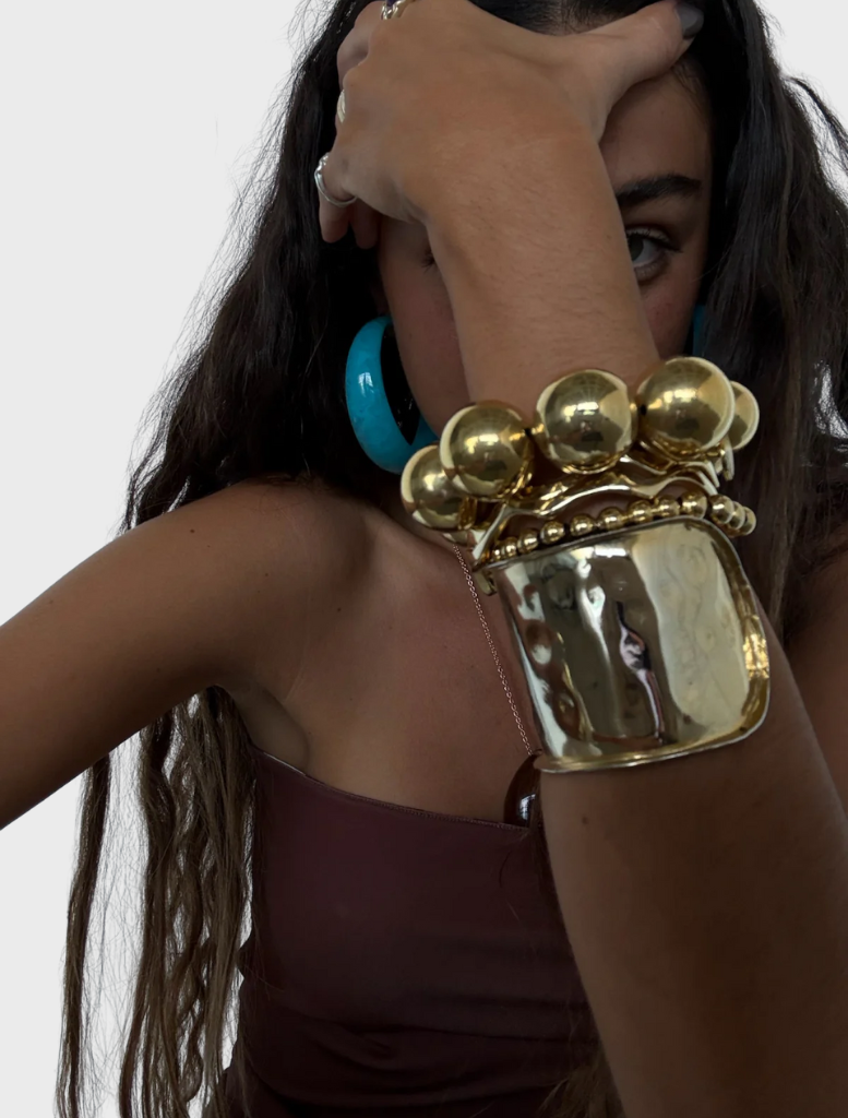 A gold bracelet adorned with a large spherical charm.