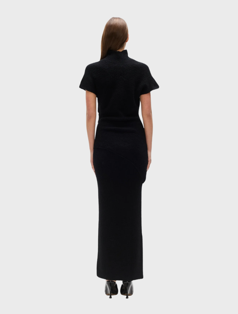 Black Evren knit top draped on a mannequin, illustrating its contemporary design and cozy material.