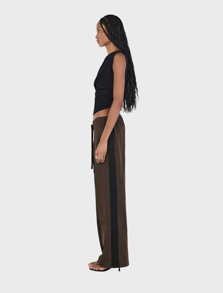 A black wool top by Pip, featuring a classic cut, hanging against a neutral background.