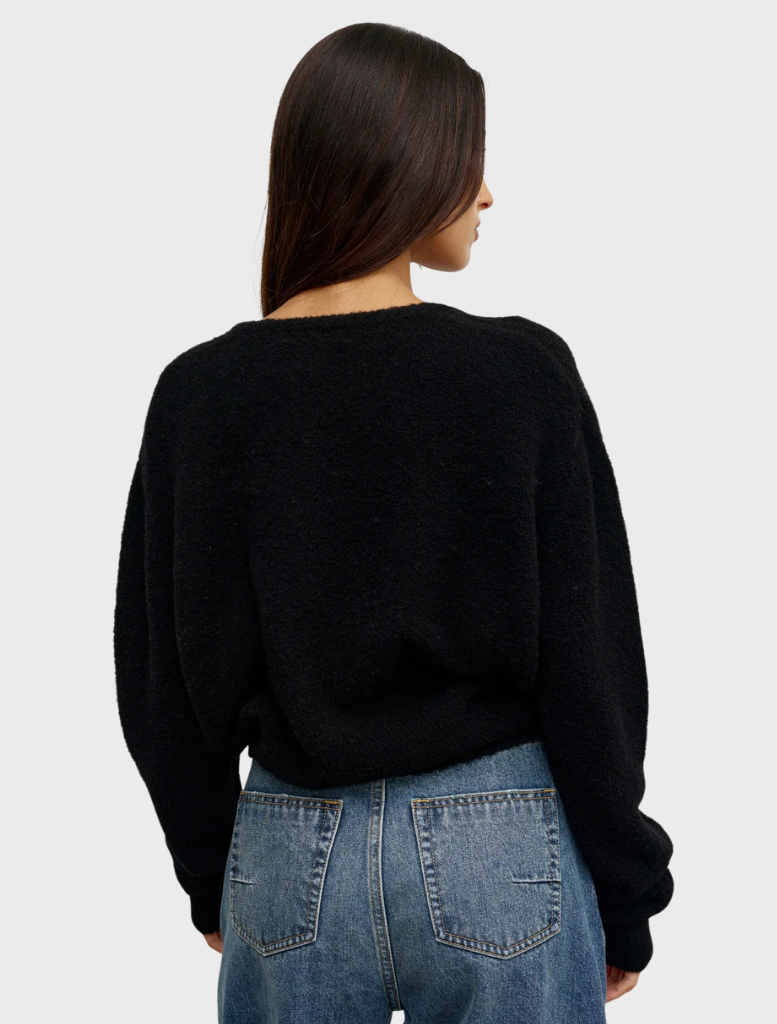 Black Sonia V-neck shirt laid flat, emphasizing its stylish cut and smooth fabric.