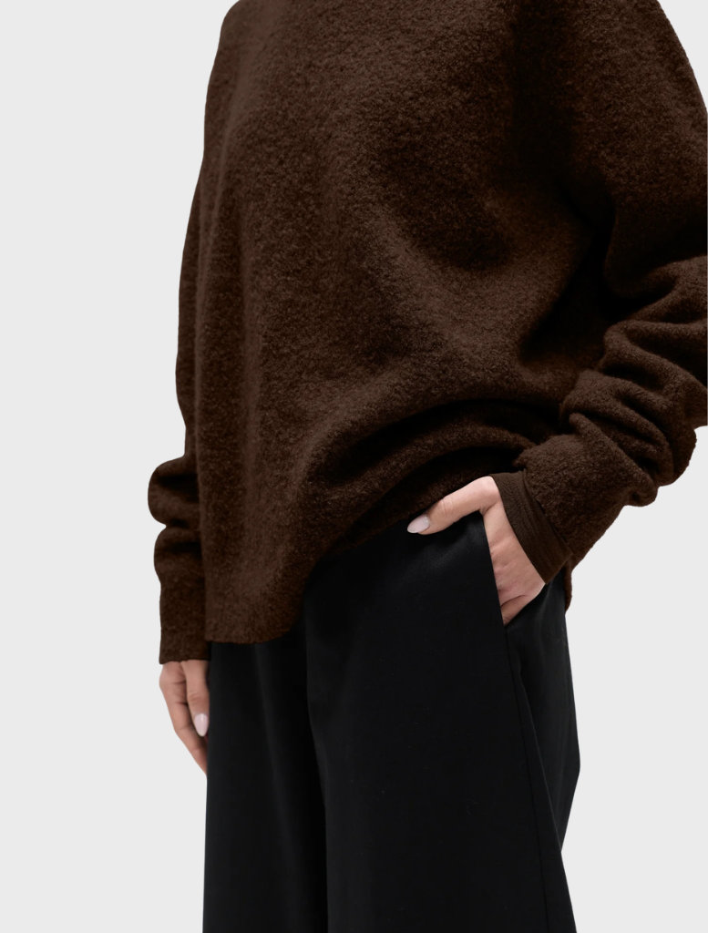A stylish crew neck sweater adorned with a bear design, ideal for comfort and warmth in cooler weather.