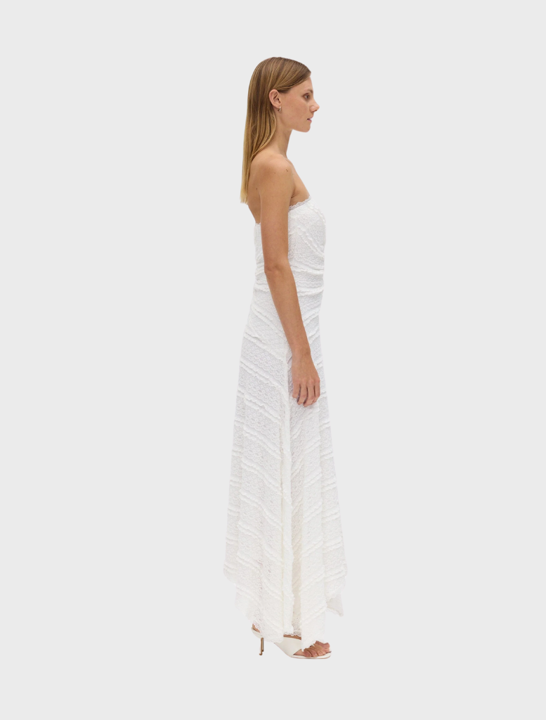 Milk-colored strapless dress with a sleek silhouette and a flowing skirt, ideal for warm weather occasions.