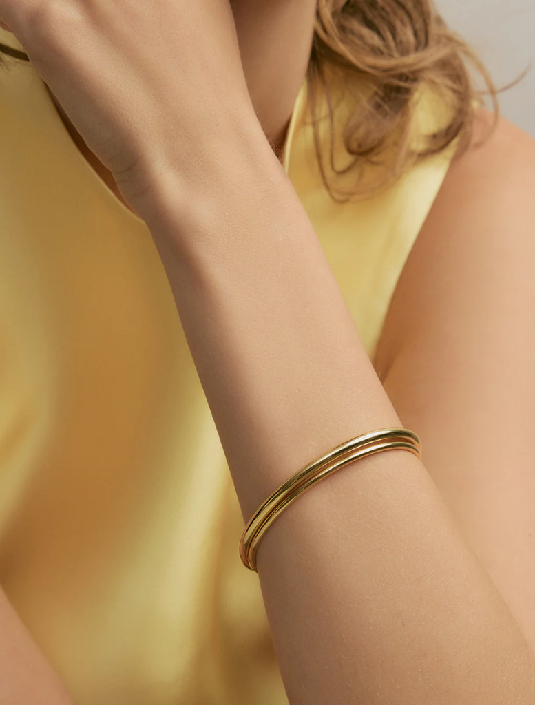 A collection of gold bangles with detailed patterns, ideal for enhancing traditional or modern outfits.