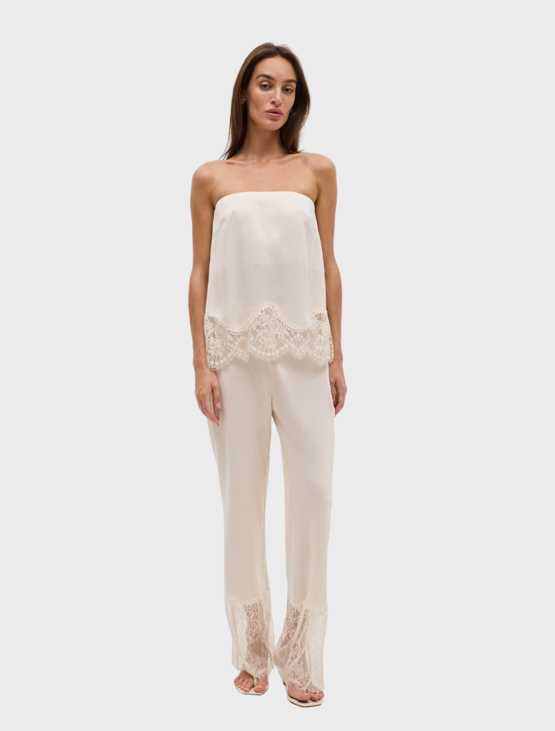Buttercream lace pant with a scalloped waistband and sheer lace panel hem, designed for a slim, fluid fit.