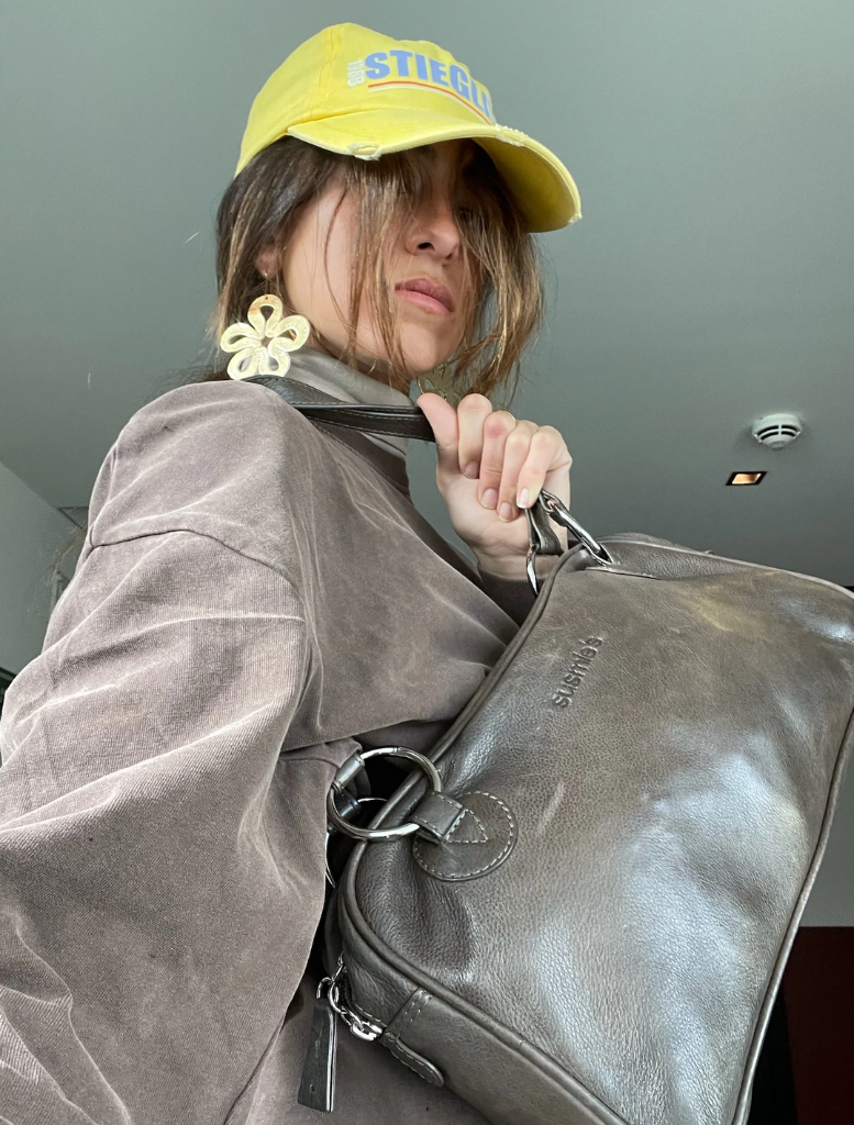 Brown leather handbag with two handles, highlighting its stylish and functional design.