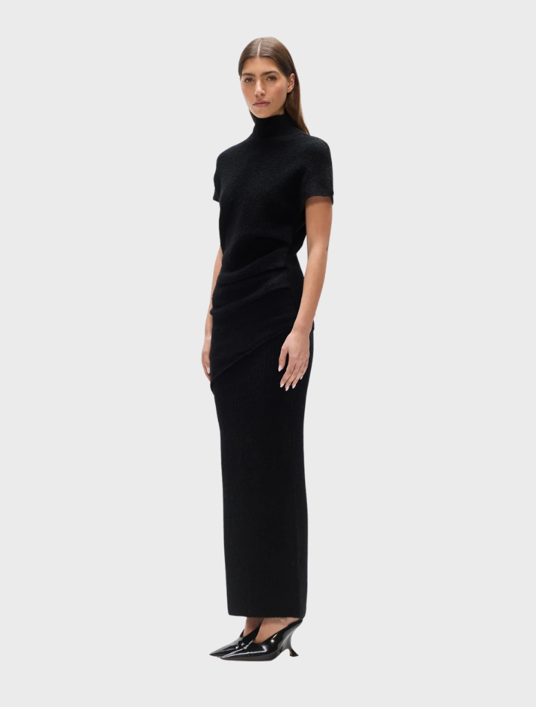 Model wearing a black Evren knit top, demonstrating its versatility and modern aesthetic.