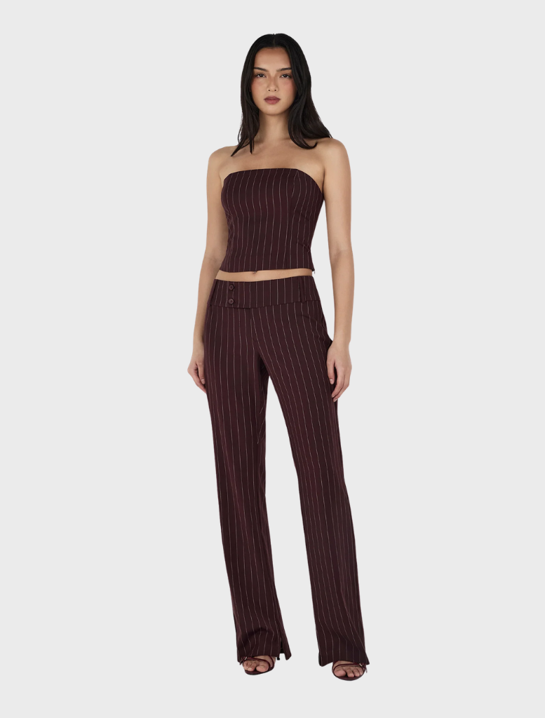 The image features a model in a burgundy striped top and wide-leg pants, specifically the Yolanda Suit Pant in Cherry Choc Stripe.