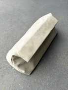 Beige leather pouch on a gray surface