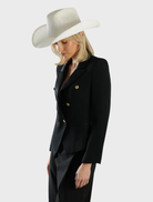White Addison Cowboy hat displayed on a wooden surface, showcasing its classic western design and stylish appeal.