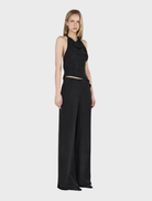 Black stretchy jumpsuit, known as Aeris Pants, offering a chic and flexible silhouette.