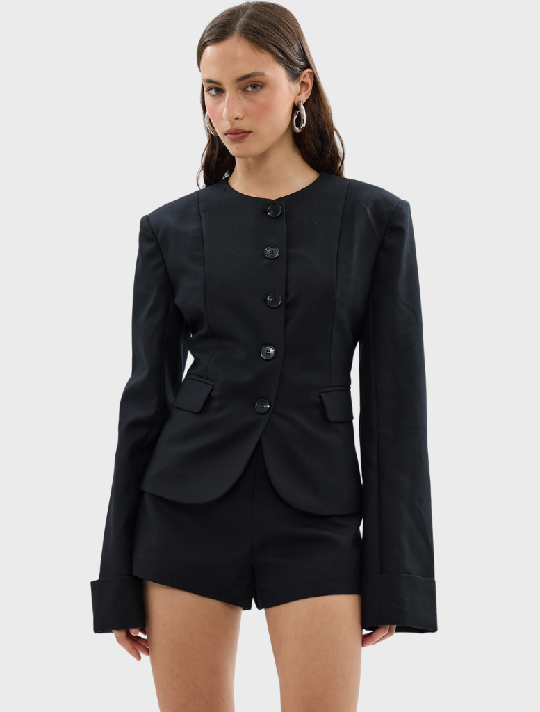 Black Alba Jacket displayed on a hanger, showcasing its sleek design and fabric texture.