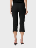 Black capri pants with a scalloped hem and elastic waistband, blending retro inspiration with modern sophistication for daily wear.