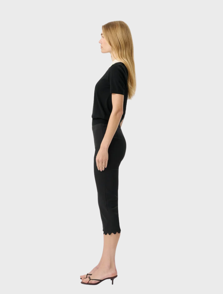 The Alfie Capri in black showcases a modern silhouette with a scalloped hem and elastic waistband for effortless style and comfort.