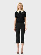 Black Alfie Capri pants feature a scalloped hem, elastic waistband, and a modern, retro-inspired silhouette for stylish comfort.