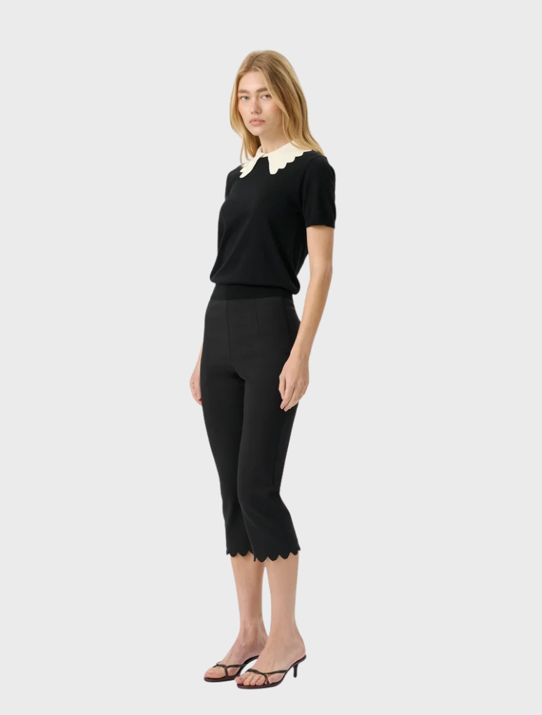 Sleek black Alfie Capri pants with a scalloped hem and elastic waistband offer a chic, retro-inspired look for everyday wear.