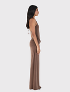 Fitted chocolate maxi dress with a halterneck, draped skirt, and gathered seams, made from sustainable materials.
