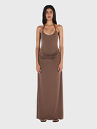Fitted chocolate halterneck maxi dress with draped skirt, gathered hips, and adjustable beaded tie closure.