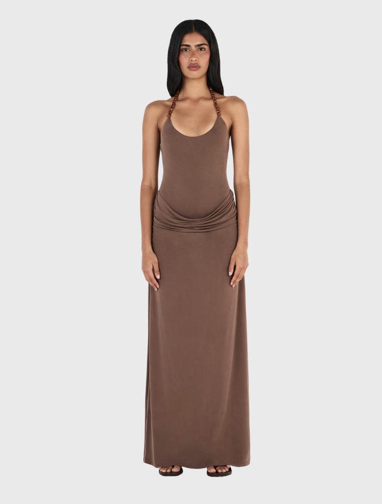 Fitted chocolate halterneck maxi dress with draped skirt, gathered hips, and adjustable beaded tie closure.