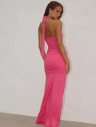 Elegant hot pink maxi dress with a halter neck and ruched detailing, ideal for warm weather occasions.