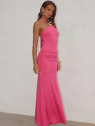 Vibrant hot pink halter maxi dress with ruched accents, designed for a chic and comfortable summer look.