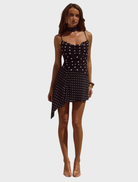 Alora mini dress featuring a scoop neck and a classic black and white polka dot pattern, perfect for casual outings.