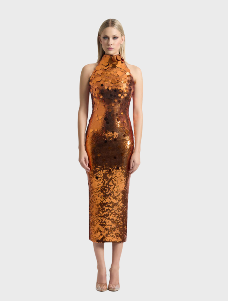 The Area Dress in orange is worn by a model, adorned with sparkling copper sequins.
