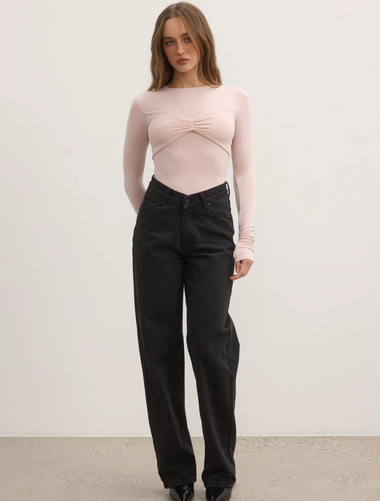 Model in black wide-leg pants paired with a pink ballet-lila bodysuit, showcasing a stylish and modern outfit.